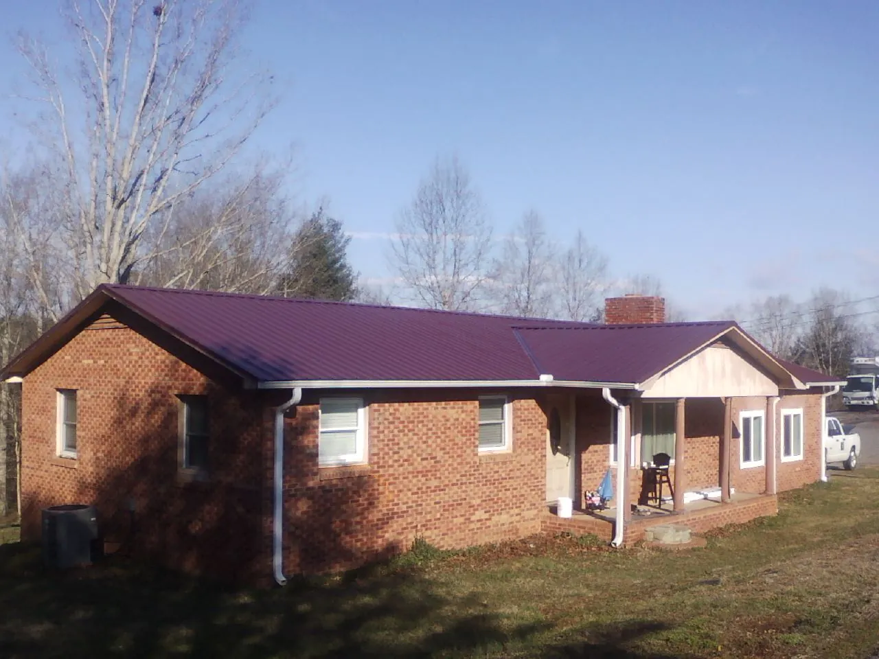 Burgundy metal roof on a brick ranch home with a new addition in Springport